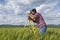 Land surveyor working with total station in the middle of wheat field