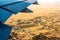 Land under the wing of an airplane from a height of flight. Desert, village, woods, fields. Amazing view from the window of the