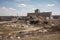 landfill with towering pile of trash, surrounded by landscape of industrial buildings