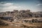 landfill with towering pile of trash, surrounded by landscape of industrial buildings