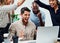 Landing the biggest deal in company history. a group of business colleagues cheering while gathered around a laptop in