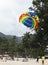 Landing on a parachute in the blue sky tropical beach. Two Chinese tourists flying on a parachute over the sea on a beach in