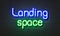 Landing space neon sign on brick wall background.