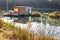 Landing stage house on wooden pier in water in forest in evening