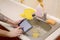 The landlord uses the tablet to call a cleaner in order to clean the clogged kitchen sink