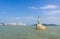 Landmark of Zhuhai city of China. Statue of Fish Woman, fisher girl stature with background of sea, island, and tall buildings