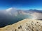 Landscape aerial travel photo of a traveler standing on the edge of a cliff overlooking Mount Ijen crater in East Java, Indonesia