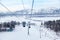 Landscape in Altay mountains with a gondola cableway booths suspended on a cable with skis and snowboards with snow on winter