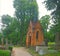 Landscape. An ancient crypt of brown stone in the form of a building, a house with a tower on the roof. Around the other crypts,