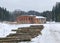 Landscape with Anfabrikas building Ligatne, wooden logs in the foreground, Ligatne, Latvia