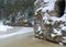 Landscape with Anfabrikas rock Ligatne, artificial caves in the rock wall, frozen river, all covered with snow, Ligatne, Latvia