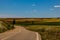 Landscape asphalt road through fields and meadows in warm summer. day Aragon Spain