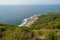 Landscape of Australian coastline with green rolling hills and blue ocean