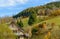 Landscape autumn countryside with wooden farmhouses on green hill and mountains in the background,Germany