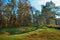 Landscape with autumn forest upon green grassland hills