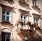 Landscape with balcony and windows with flower pots and red flowers on old building in italian style in ukrainian city Lviv,