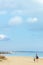 Landscape with beach, clouds, walking mother and daughter