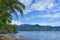 Landscape of Beach with Rocks, Hill, Trees, Blue Sky, Cloud and Buoy