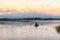 Landscape Beautiful lake in the evening with rower on the oars and small church on the horizon