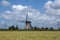 Landscape with beautiful traditional dutch windmill with blue sky and clouds