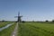 Landscape with beautiful traditional dutch windmills near the water canals with blue sky and clouds reflection in water