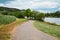 Landscape with a bicycle path or sidewalk at the river Moselle in Trier, rhineland palatine in Germany, summer at the valley