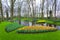 Landscape with blooming beautiful flowers and water stream in Keukenhof