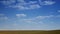 Landscape blue sky with clouds running over the field. Horizon of the field, shot from a distance. Accelerated video the day is