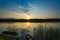 Landscape with boat and dramatic sunset with dense grasses