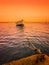 Landscape of a boat in the sea, tied with rope to the beach at Atakum Beach, a warm and orange sky.