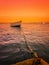 Landscape of a boat in the sea, tied with rope to the beach at Atakum Beach, a warm and orange sky. Version 2