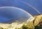 Landscape with bright rainbow in the mountains against stormy sky