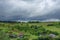 Landscape with charming little houses, agricultural fields and dramatic sky in Transylvania countryside, Romania