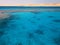 Landscape of clear blue natural sea salt water, sea, ocean with waves with a bottom of beautiful coral reefs, stones against the b