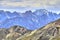 Landscape with colorful steep rocky slope and beautiful Himalaya mountains in the background, Ladakh, India