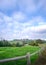 Landscape of a country home with green meadows on a valley with a cottage at the background