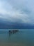 Landscape with dark sky with storm clouds over the ocean. Destroyed pier at Bophut beach on Koh Samui in Thailand.