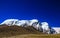 Landscape of deep blue sky and ice capped peaks of himalayan mountains with white clouds during day time