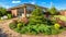 Landscape design at residential house. Landscaping with paved path in home garden. Panoramic view of landscape garden in backyard