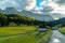 Landscape of Dolomites with green meadows, blue sky, white clouds and rocky mountains. Italian Dolomites landscape. Beauty of natu