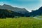 Landscape of Dolomites with green meadows, blue sky, white clouds and rocky mountains. Italian Dolomites landscape. Beauty of natu