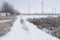 Landscape with an earth road near high-voltage lines after hoar-frost attack