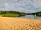 Landscape with empty beach, green flag, sunny summer morning, reflections in water, summer