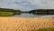 Landscape with empty beach, green flag, sunny summer morning, reflections in water, summer