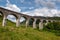 The landscape with famous Glenfinnan Viaduct in Scotland in perspective view from bottom with blue sky and clouds