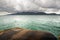 Landscape with ferry ramp, tropical sea, monsoon storm heavy clouds and tropical Koh Chang island on horizon in Thailand