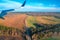 Landscape fields surrounded by forests from the window aircraft. View of farmland from a bird`s-eye view. Top view.