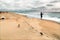 Landscape with fishman, sea gulls and sandy steps. Sunny white clouds blue sky.