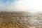 Landscape of fog lifting over an endless wadden sea beach at low tide
