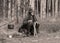 Landscape with a forester in the woods by the fire, a worker drinks tea and warms up by the fire, sepia